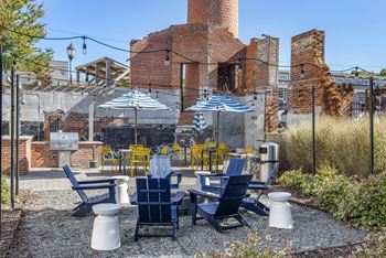 A patio with blue and yellow chairs and umbrellas